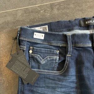 Blå jeans från Replay - Snygga blå jeans från Replay med klassisk femficksdesign och knappgylf. Jeansen har en modern passform och är tillverkade i ett slitstarkt denimtyg. Perfekta för en stilren look. Storlek 38 men anbass är väldigt tighta så passar även 36. Bara höra av dig om du har frågor 🤩