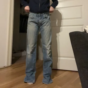 Blå jeans från Massimo Dutti - Säljer ett par blå/grå jeans från Massimo Dutti med straight fit. De har en klassisk design med slitningar på benen och en bekväm passform. Perfekta för en avslappnad stil.