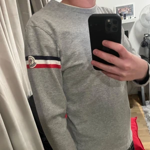 Grå långärmad tröja från Moncler - Säljer nu denna feta tröja från moncler eftersom jag växt ur den. Den är i storlek S men passar som xs. Självklart äkta💫Det är en lite gammlare modell så den har certilogo, skick 9/10 inga defekter eller skavanker. Priset är ej hugget i sten 🪨 Hör av er om ni har några frågor! Mvh, herkus