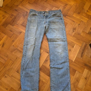 Levi's 501 jeans i ljusblå denim vintage - Klassiska Levi's 501 jeans i ljusblå denim. Dessa jeans har en rak passform och är tillverkade av 100% bomull. Perfekta för en avslappnad stil med knappgylf och femficksdesign.