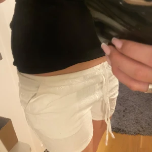 Linne shorts - Säljer ett par vita linne shorts med knytband i midjan. Perfekta för varma sommardagar. De har en avslappnad passform och är gjorda i ett lätt material.