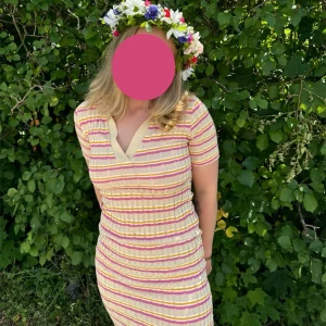 Randig klänning från Zara - Säljer en färgglad randig tight klänning från Zara med korta ärmar och v-ringning. Klänningen har en mix av rosa, gul och beige ränder. 