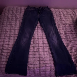 Blå bootcut jeans - Snygga blå bootcut jeans med klassisk femficksdesign. Perfekta för en avslappnad stil. De har en dragkedja och knapp framtill. Storlek: 36