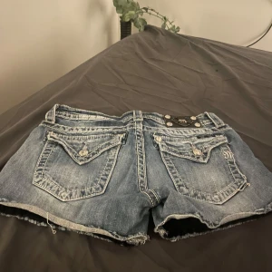 Blå jeansshorts från Miss Me - Snygga blå jeansshorts från Miss Me med coola detaljer. Storlek W28 