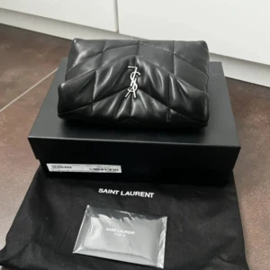 Saint Laurent väska  - Säljer min superfina väska/clutch från Saint Laurent, andvänd 2 gånger så är i nyskick! 😊🫶🏻❤️Köpt från Schweiz, äkthets bevis, original förpackning och plånbok tillkommer! Kan gå ner i pris vid snabb affär!!❤️ Vill ni ha bilder är det bara att skriva⭐️