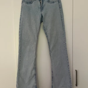 Ljusblå bootcut jeans - Snygga lågmidjade ljusblå bootcut jeans. Perfekta för en avslappnad stil. Klassisk femficksdesign och knappgylf. Passar bra till sneakers och vilken överdel som helst.  