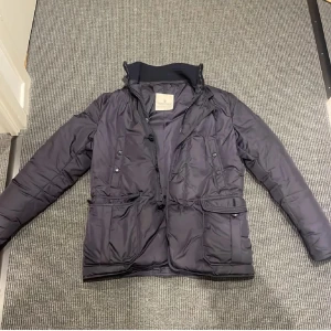 Moncler jacka  - Säljer en blå jacka från moncler. Storlek 2 vilket motsvara S/M. Skicket är 8,5/10 saknar en knapp på fickan annars super. Perfekt till kyligare dagar men funkar även bra till våren