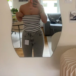 Grå jeans  - Snygga grå jeans. De har en hög midja och raka ben, vilket ger en tidlös look. Perfekta för en avslappnad stil.