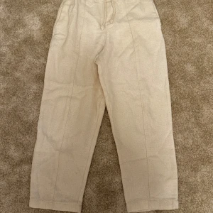 Beige byxor från Zara - Snygga, vida byxor i en ljus beige nyans. Byxorna har en bekväm, ledig passform med dragsko i midjan. De har en rak benlinje och en enkel, elegant design.   Kombinera med alla typer av kläder och den passar till nästan allt Märke: Zara Storlek :M Skick: 9/10  ord. Pris 399