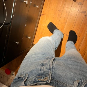 Blå jeans från Jack & Jones - Säljer ett par blå jeans från Jack & Jones i modellen Loose/Chris. De har en avslappnad passform och klassisk design med dragkedja och knappar. Perfekta för en casual look. Sitter mer som 33/32