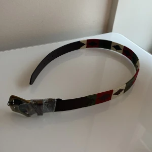 Polo skärp från farrar & tanner - Snyggt bälte i full grain läder med ett färgglatt mönster i rött, grönt, beige och svart. Aldrig använt. Storlek 32. Nypris 715kr. Tveka inte på att fråga om det är något du undrar.