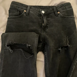 Svarta jeans med slitningar - Snygga svarta bootcut jeans med slitningar på knäna. Lågmidjade. Priset kan diskuteras💕