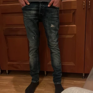 Jeans  - Tjena, jag säljer min byxor, då jag har vuxit ut dem. För att den skulle bli snyggare så sydde jag fast en marinblå tyglapp innanför hålet övanför knät, som ni kan se på de 3 första bilderna. Dem är slim och borde passa dig som är runt 170-175. 