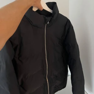 Pufferjacka H&M - Svart pufferjacka från H&M i storlek L. Nyskick, endast använd någon gång. Nypris 1200:-