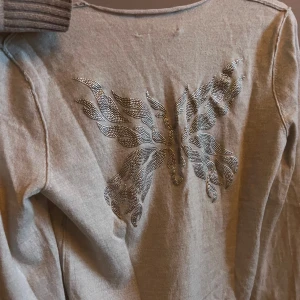 Beige tröja med fjärilsdetalj - Zadig voltarie tröjan i kashmir med en v-ringad design med en jättecool detalj på ryggen