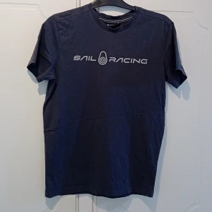 Sail Racing t shirt - Säljer en snygg grå t-shirt från Sail Racing i storlek S. Den har en stilren design med loggan tryckt på framsidan. Perfekt för en avslappnad stil. T-shirten är i bra skick och passar till både vardag och fritid.. Använd ett fåtal gånger. 100 % bomull. Kommer från ett rök och djur fritt hem.