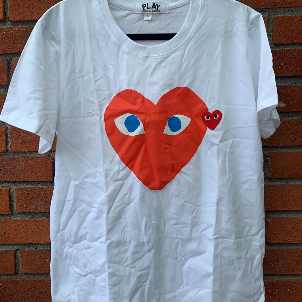 Säljer en supersnygg CDG t-shirts. Den är i bra skick och är vit med röda detaljer.R,ep . T-shirts.