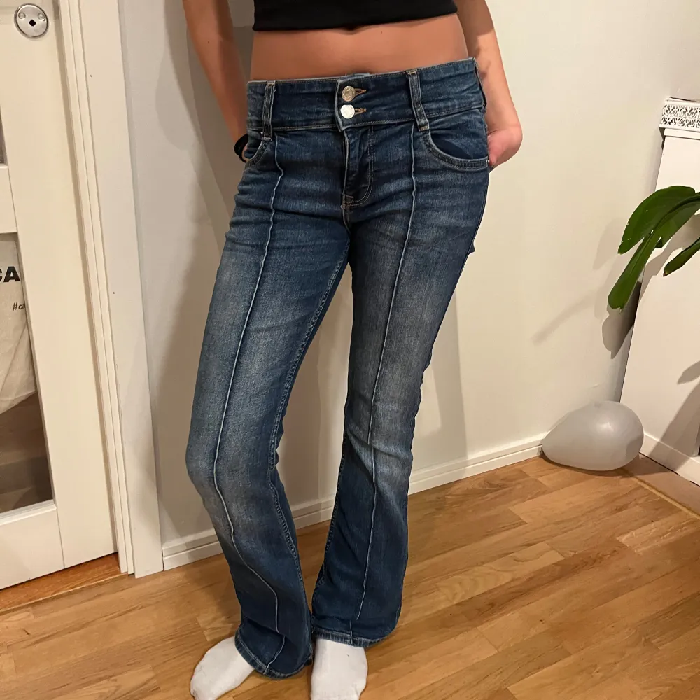 Säljer ett par snygga blå bootcut jeans i bra skick. De är lågmidjade med sträck i mitten. Jag är 168 och de passar precis. Obs! Lappen är borta!! Använt 2 gånger💕. Jeans & Byxor.