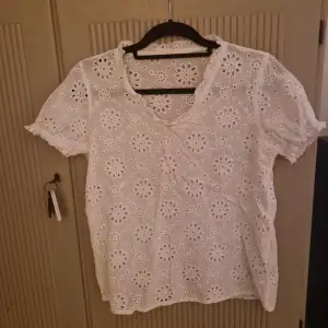 Säljer en superfin vit blus med broderade blommor. Den har en v-ringad hals och korta ärmar. Perfekt för sommardagar eller en avslappnad vårlook. Blusen är i mycket bra skick och ger en romantisk touch till vilken outfit som helst.