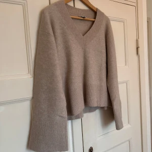 Beige alpacka-blandning från & Other Stories - Superfin beige Alpacka-blandad tröja från & Other Stories. Den har en v-ringad design och långa ärmar, perfekt för höst och vinter. Tröjan är i mycket bra skick och känns lyxig och mjuk mot huden. Perfekt för att hålla sig varm och stilren under kyliga dagar.