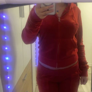 Röd juicy couture set  - Säljer ett supermjukt och bekvämt röd velour set med dragkedja. Perfekt för mysiga dagar hemma eller en avslappnad dag ute. Den har långa ärmar och en skön passform. Passar perfekt till höst och vinter!