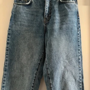 Blå jeans från Gina Tricot - Säljer ett par snygga blå jeans från Gina Tricot i storlek 36. De är tillverkade av mer hållbar bomull och har en klassisk fyrficksdesign. Perfekta för både vardag och fest! 🦋Byxorna är fabriksslitna längst ner, på fickorna och i midjan men det är köpta så och ska vara så. Köparen betalar frakt. 