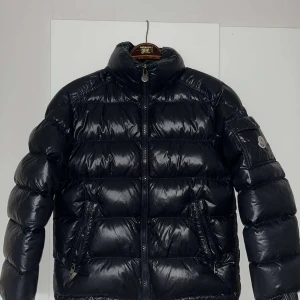 Moncler Maya - Säljer en snygg svart pufferjacka från Moncler i mycket bra skick, däremot försvann luvan i flytten därav det låga priset. Strl 1 vilket motsvarar S/M. Skriv gärna vid fler frågor😁