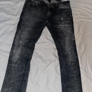 Svarta jeans från Diesel - Säljer ett par svarta Diesel Thavar jeans i bra skick. De har en snygg, sliten look och är perfekta för både vardag och fest. Jeansen är i passform slim. Nypris ligger på nästan 1300-1400kr mitt pris är 900kr. Pris kan ändras vid snabb affär. Har ni några funderingar kontakta mig🙌🙌