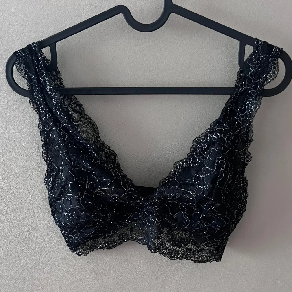 Säljer en elegant svart spets bralette i mycket bra skick. Den har ett vackert blommigt mönster och är perfekt för att lägga till en touch av lyx till din outfit. Braletten är bekväm och stilren, idealisk för både vardag och speciella tillfällen.. Toppar.