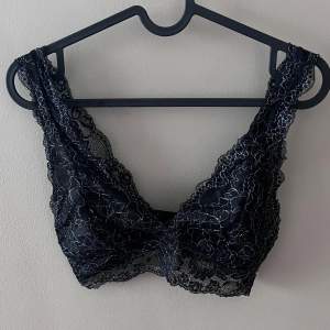 Säljer en elegant svart spets bralette i mycket bra skick. Den har ett vackert blommigt mönster och är perfekt för att lägga till en touch av lyx till din outfit. Braletten är bekväm och stilren, idealisk för både vardag och speciella tillfällen.