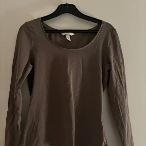 Brun långärmad topp - Säljer en enkel och stilren brun långärmad topp. Den är i gott skick! Kommer från HM och är lite mindre i storleken.