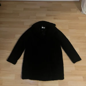 Damjacka - Mysig svart teddyjacka från Noisy May i storlek M. Perfekt för kalla höst- och vinterdagar. Jackan har långa ärmar och en skön, fluffig textur som håller dig varm och stilren. 