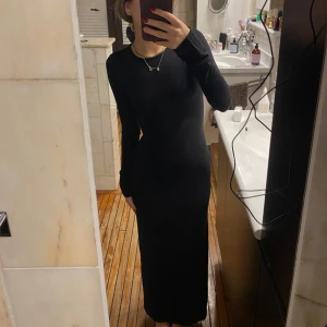 Svart långklänning - Säljer en elegant svart långklänning i mycket bra skick. Den har en tight passform och långa ärmar, perfekt för höst och vinter. Klänningen är stilren och passar både till vardags och festliga tillfällen. Ett måste i garderoben för den som älskar klassisk stil!