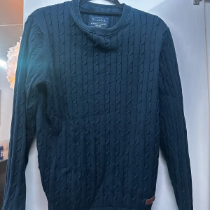 Mörkblå stickad tröja från Bondelid - Säljer en snygg mörkblå stickad tröja från Bondelid i storlek S. Tröjan har ett klassiskt flätmönster och är perfekt för kyliga dagar. Den är i mycket bra skick och passar både till vardags och lite finare tillfällen. Perfekt för höst och vinter! 🍂❄️
