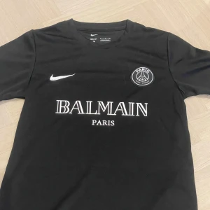 Balmain PSG T-shirt - Storlek S - Hej! Jag säljer den fina och eftertraktade PSG T shirten! Den är oanvänd, fick den som present. Fint skick. Skön till sommar eller idrott osv.