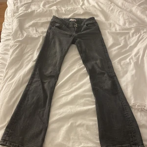 Grå jeans från Gina Tricot - Säljer ett par snygga grå jeans från Gina Tricot i storlek 152. De har en klassisk femficksdesign och stängs med två knappar och dragkedja. Perfekta för både vardag och fest! 🖤