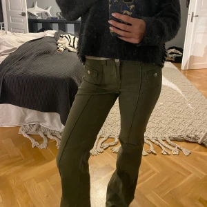 Gröna jeans - Säljer ett par gröna jeans i bra skick. De har en tight passform och är lågmidjade med flera fickor och knappar som detaljer. Super bra skick! Passar även st 34