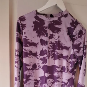 Långärmad topp med mönster - Två snygga långärmade toppar med unika mönster. Den första är lila med ett abstrakt mönster, perfekt för en cool och avslappnad stil. Den andra har ett ormskinnsmönster i bruna och svarta toner, vilket ger en edgy look. Båda topparna är i bra skick och passar perfekt för höstgarderoben.