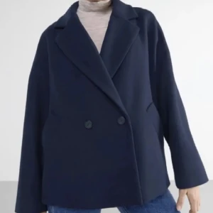 Mörkblå kappa - Säljer en stilren mörkblå kavaj i mycket bra skick. Den har en klassisk design med dubbelknäppning och långa ärmar. Perfekt för höst och vår. Passar till allt🩷
