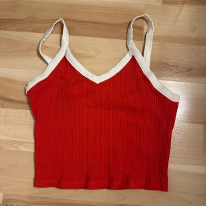 Röd ribbad linnetopp från Monki - Säljer en superfin röd ribbad linnetopp från Monki i storlek S. Toppen har vita kanter och smala axelband, perfekt för sommardagar eller en avslappnad fest. Den är i bra skick och redo för nya äventyr! 🌟
