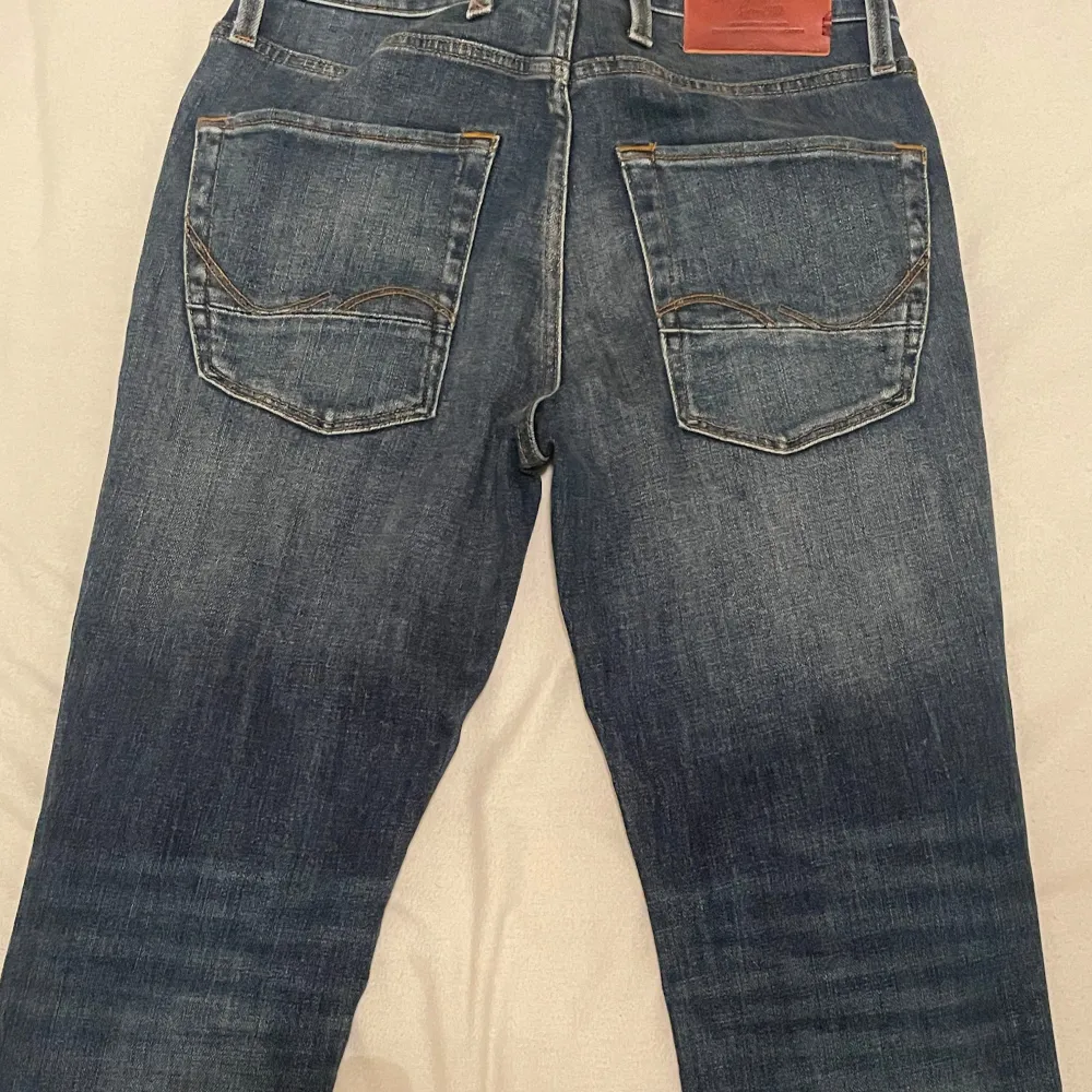 Säljer ett par snygga blå jeans från Jack & Jones i modellen Slim Straight Tim. De har en klassisk femficksdesign och är i mycket bra skick. Perfekta för både vardag och fest! NYPRIS: 999,95kr Priset kan diskuteras. Jeans & Byxor.