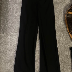 Svarta kostymbyxor från Nelly - Säljer ett par stilrena svarta byxor från Nelly i storlek XS passar S med. Aldrig använda så nyskick🥰