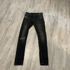 Svarta jeans från J&J bra skick - Säljer ett par svarta jeans ifrån Jack and Jones i bra skick. De har en snygg mörk tvätt och modellen är Slim Glenn. Jeansen har inga alls skador eller fel. Skulle säga skick 8,5/10. Storleken är W29 L34 men funkar som L33 ochså. Skriv vid minsta lilla fundering eller fråga. Pris kan diskuteras.