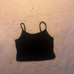 Svart ribbad linnetopp från FB Sister - Säljer en svart ribbad linnetopp från FB Sister i storlek xxs.