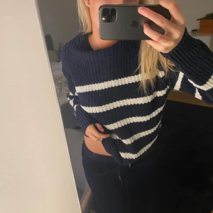 Randig stickad tröja - Säljer en supermysig randig stickad tröja i marinblått och vitt. Den har en loose passform och långa ärmar, perfekt för kyliga dagar. Tröjan är croppad och ger en avslappnad look. Perfekt för höst och vinter!