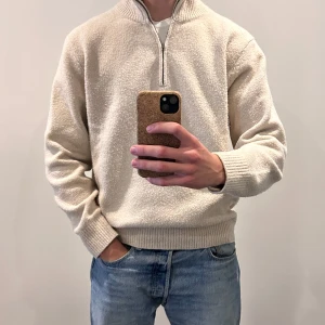 Uniqlo Half-Zip Beige, Storlek L - Beige half-zip tröja från Uniqlo i bra skick. Inga defekter eller fläckar förutom att tröjan är lite nopprig. Tröjan är nytvättad och kommer från ett djur- och rökfritt hem. Tröjan köptes för 499 kr.  Hör gärna av dig om du har några frågor eller funderingar!
