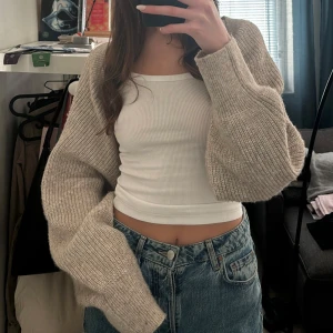 Beige stickad bolerotopp - Säljer en superfin beige stickad bolerotopp. Den är croppad och har långa ärmar! Storlek XL men ser även fin ut oversized! 