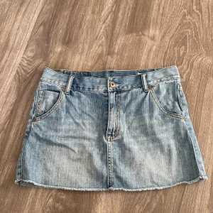 Jeanskjol i ljusblå denim - Säljer en superfin jeanskjol i ljusblå denim. Den har en klassisk femficksdesign och en rå kant nertill för en avslappnad look. Perfekt för sommardagar eller en casual utekväll. Passar bra med en t-shirt eller en söt blus. 🦋
