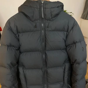 Svart dunjacka från Peak Performance - Säljer en svart dunjacka från Peak Performance i storlek M. Använd 2 vintrar men fortfande bra skick. Perfekt för kalla vinterdagar och håller dig varm och bekväm. Nypris ≈4000 