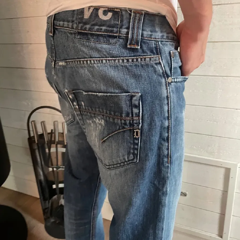 Säljer ett par snygga blå jeans från Dondup med coola slitningar. De har en klassisk femficksdesign och en bekväm passform. Perfekta för en avslappnad stil och funkar året runt. Passar både till vardags och fest!. Jeans & Byxor.